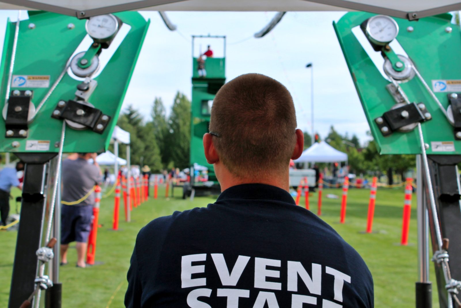 staff attendant operating a mobile zip line at a company picnic