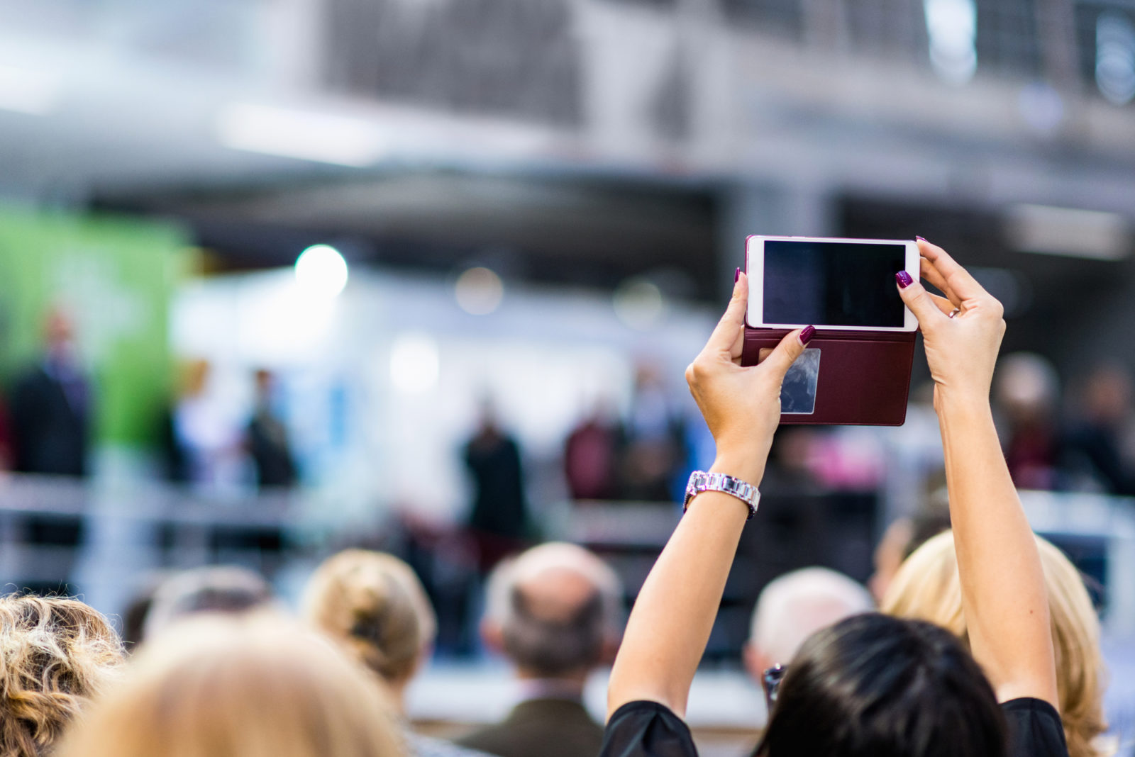 trade show attendee taking a photo of the stage